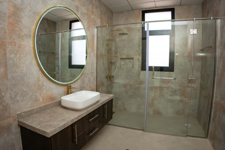 Bagno elegante con vasca freestanding, doccia vetrata, doppio lavabo tondo e rubinetteria nera