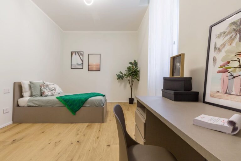 Camera con letto singolo, scrivania e parete decorata, ottimizzazione spazi in appartamento Milano