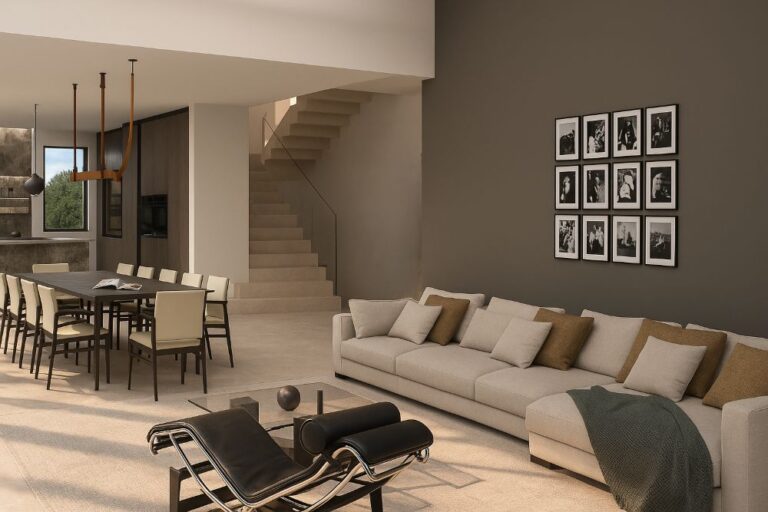 Zona living con divano chiaro, chaise longue moderna e scala in pietra con parapetto in vetro