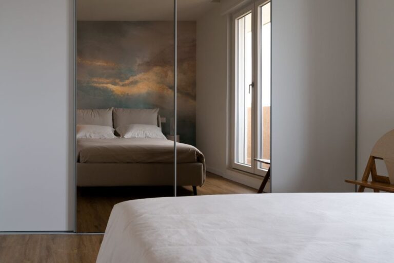 Camera da letto con carta da parati artistica e armadi a specchio, progettata a Monza