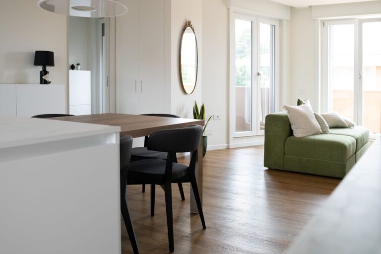 Vista laterale di cucina open space con zona pranzo e living, ristrutturazione d'interni a Monza