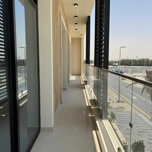 Balcone moderno con pavimento chiaro e ringhiera in vetro su vista urbana a Dubai