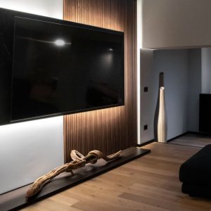 Parete TV retroilluminata con boiserie e oggetto decorativo in legno