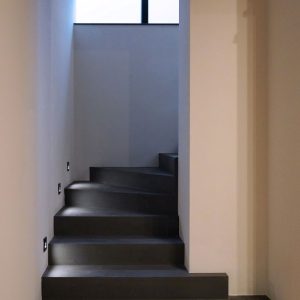 Scala in cemento grigio scuro con luci integrate a parete